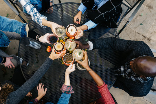 Overhead photo of friends toasting cocktails