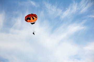 parasailing against the blue sky with light clouds