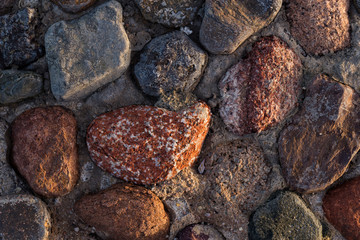 Background of colored stones. The surface is decorated with natural material. Pattern on the floor of multicolored pebbles.