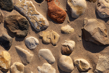 Background of colored stones. The surface is decorated with natural material. Pattern on the floor of multicolored pebbles.