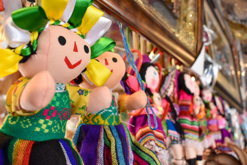 Colorful dolls hang from a vender's store