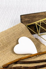 Composition with ceramic heart, wood case, sticks and canvas. Love card, mockup, blank space for text.