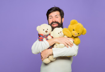 Smiling man hugs Teddy bears plush toys. Birthday or anniversary. Gift and present. Holiday. Celebration. Happy man hugs teddy bear. Bearded man with plush toy. Teddy bear. Man with fluffy teddy bear.