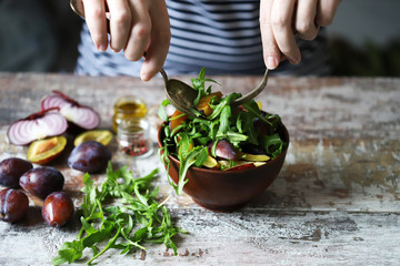 Healthy arugula plum salad. Selective focus. Macro.