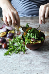 Healthy arugula plum salad. Selective focus. Macro.