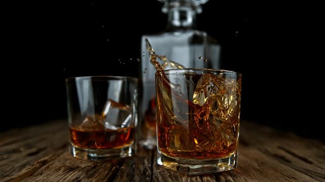 Super Slow Motion Shot of Ice Drop into Glass with Whiskey at 1000fps with Camera Movement.