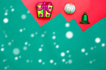 present box ,bauble and green ring on red and green background with copy space for new year and christmas time with snow fall