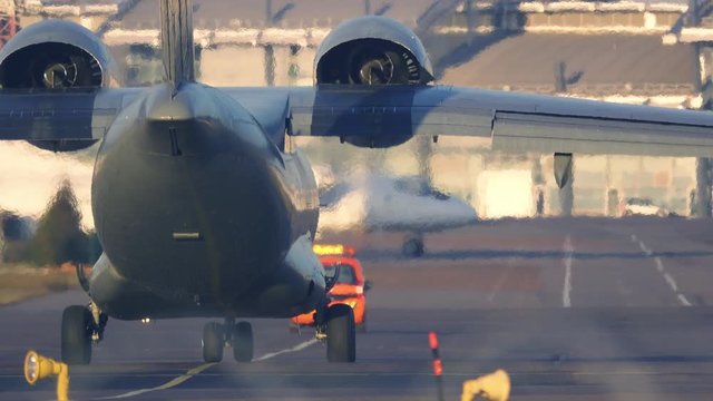 Military airplane taxiing on the taxiway after landing
