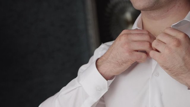 slow motion. concept of business, wedding, fashion, dressing up, groom, fiance and clothing. business man hands buttoning white shirt. getting ready for work closeup