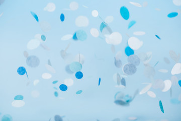 Blue falling confetti on pastel blue background