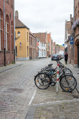 Fototapeta na wymiar Row of Bikes on Cobblestone Street in Bruges