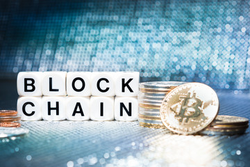 Closeup, BLOCKCHAIN on blocks with stacks of gold and silver bitcoins on colorful futuristic, sparkling background, Cryptocurrency for digital assets and transactions in financial / banking industry