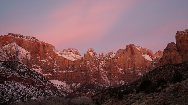 Cliffs in Zion lit up during colorful sunrise.