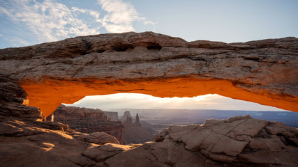 Sunrise of Mesa Arch lighting up and glowing in the Utah desert of Canyonlands.