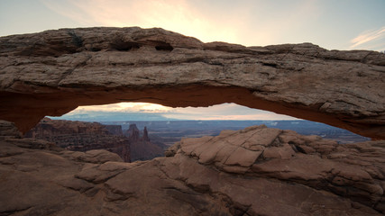 Mesa Arch as the sun starts to rise lighting up the clouds at dawn.