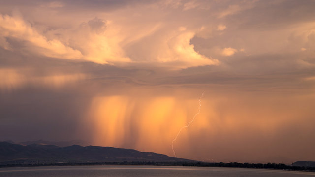 Sunrise storm with lightning strike looking past Utah Lake.