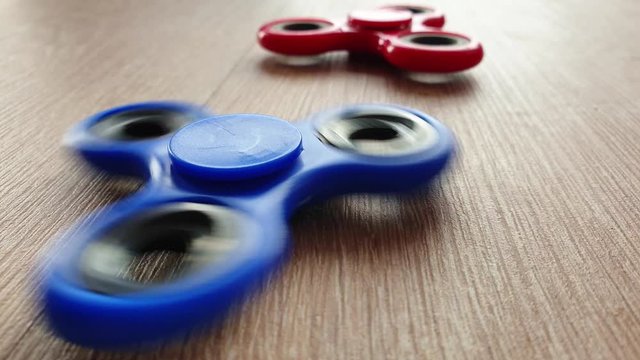 two spinning finger spinners on the table red and blue