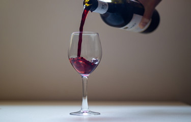 wine being poured into the glass bowl with the movement of the wine as it touches the edges of the glass.