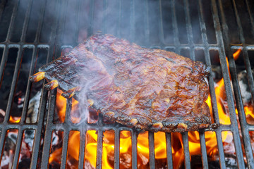 Grilled ribs on the hot flaming grill.