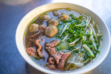 Closeup photo of Vietnamese Pho noodles soup bowl on table