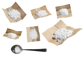 Group of cocaine in paper and spoon isolated on white background