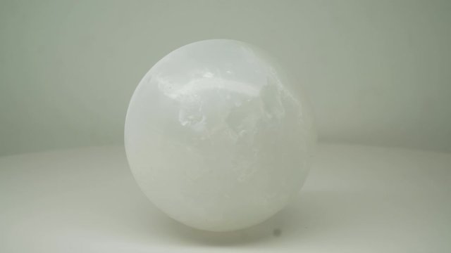 White Crystal Round l Magic Ball Rotating Clockwise With Pure White Background -Close Up Shot