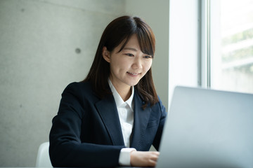 オフィスでパソコンを使って働く女性