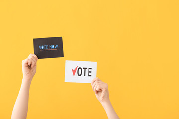 Hands of voting people with paper sheets on color background