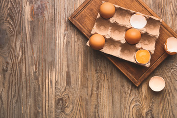 Package with fresh eggs on wooden table