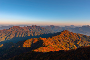 Fototapeta premium The horizon line is normally covered with morning mist in autumn on the peak of Chunmasan Mountain in Seoul, South Korea.