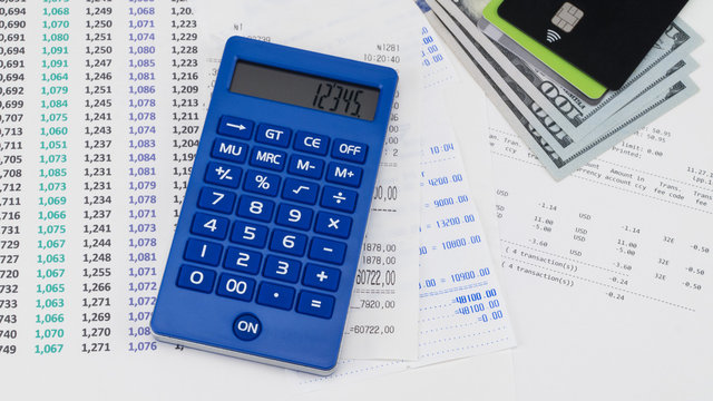Payment card and calculator on top of supermarket receipt. Shopping and payment concept