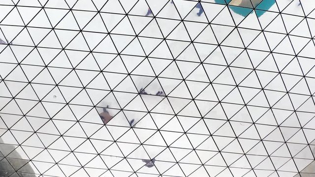 reflection in the mirrored ceiling going on business people. the ceiling is made of a pieces of mirrors and people are refracted when they move.