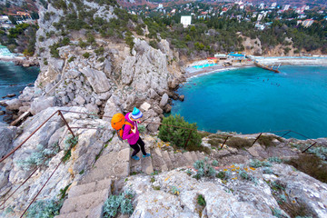 A woman descends the steps from the top of the mountain.