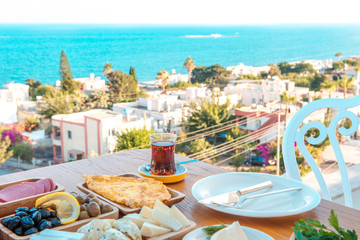 Obraz premium Breakfast on the beach at hotel or resort by the sea in summer season. Holiday and vacation breakfast image.Traditional Turkish or Greek breakfast at bodrum town beach in Turkey or Greece