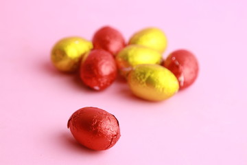 Fototapeta na wymiar chocolate easter eggs, wrapped in yellow and red paper