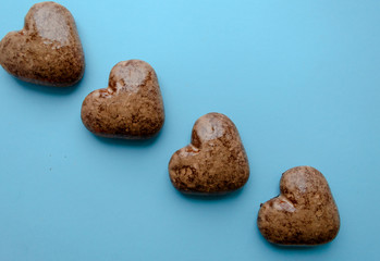 Valentine's flat lay with love chocolate gingerbread heart on colorful blue background, greeting card copy space top view. The celebration of Valentine's Day.