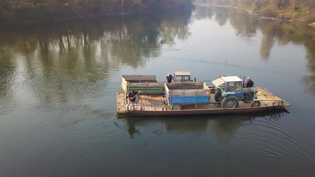 Old manual powered cable ferry for agricultural machinery transport across the river in rural countryside