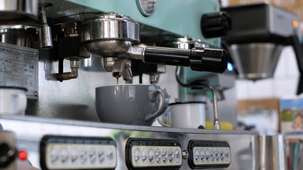 Barista at work. The process of making coffee and cacao. A glass of foaming milk. Electric Grinder Grinds Coffee Beans In Filter Holder.