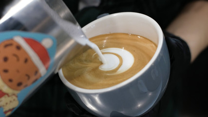 Barista at work. The process of making coffee and cacao. A glass of foaming milk. Electric Grinder Grinds Coffee Beans In Filter Holder.