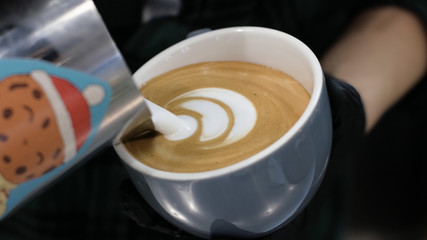 Barista at work. The process of making coffee and cacao. A glass of foaming milk. Electric Grinder Grinds Coffee Beans In Filter Holder.