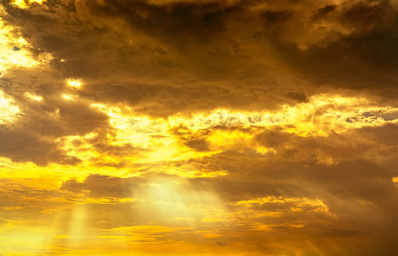 God light. Dramatic golden cloudy sky with sun beam. Yellow sun rays through  golden clouds. God light from heaven for hope and faithful concept. Believe in god. Beautiful sunlight sky background.
