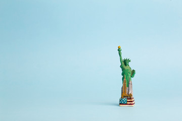 Statue of Liberty on a blue clean background. Toy model of the Statue of Liberty as a souvenir from...