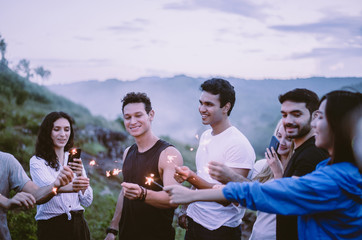 Cheerful diversity friends with sparklers and enjoying together at outdoor,Happy new year concept