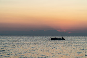 Obraz premium Boat in the middle of the sea during sunset
