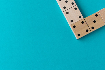 Playing dominoes on a blue background. Leisure games concept. Domino effect.