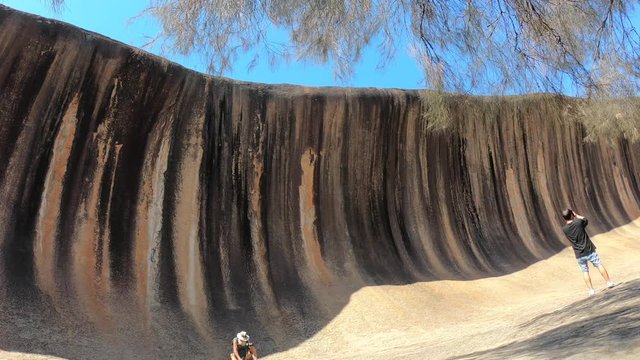 Time lapse of tourists visiting at Wave Rock, a natural rock formation shaped like a tall breaking ocean wave (15m high and 110m long) located near Hyden in Western Australia.