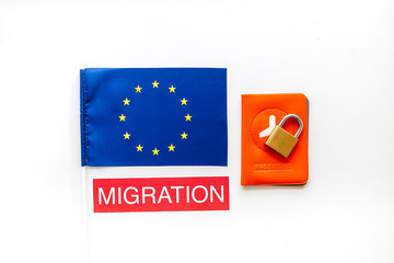 Migration to Europa concept. European flag near passport and lock on white background top-down