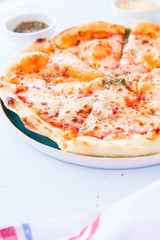 Pizza margherita in a plate on a blue background.