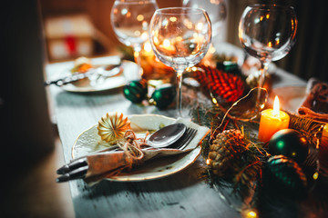 Table served for winter dinner in living room. Close up view, table setting. Christmas and winter decorations in blue colors. Beautiful served table with decorations