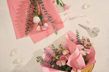 Making pink flowers bouquets with scissor on white background. Holiday, mothers day, valentine day...
